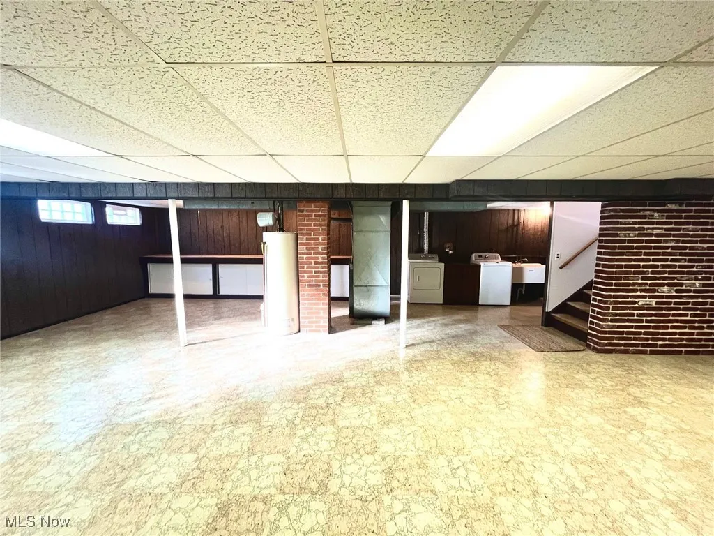 Finished basement with view of steps and utility areas