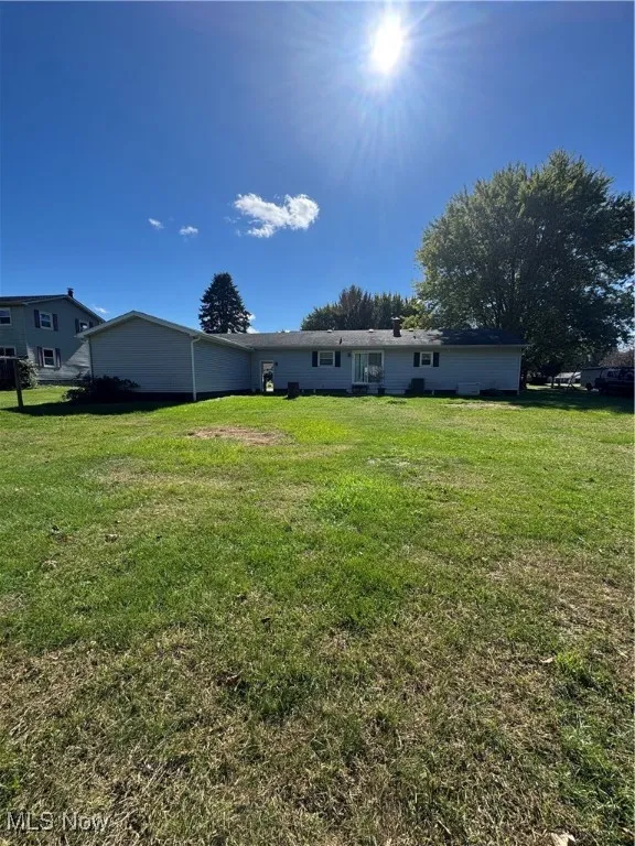 Back of house with a lawn