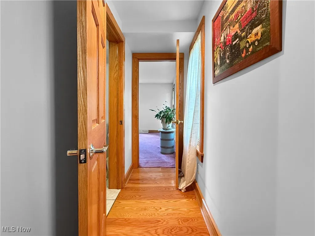 Hall featuring light wood-style floors and baseboards