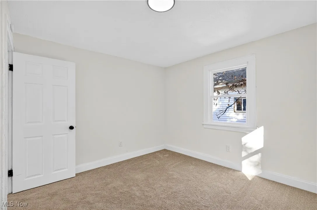 Spare room featuring light colored carpet and baseboards