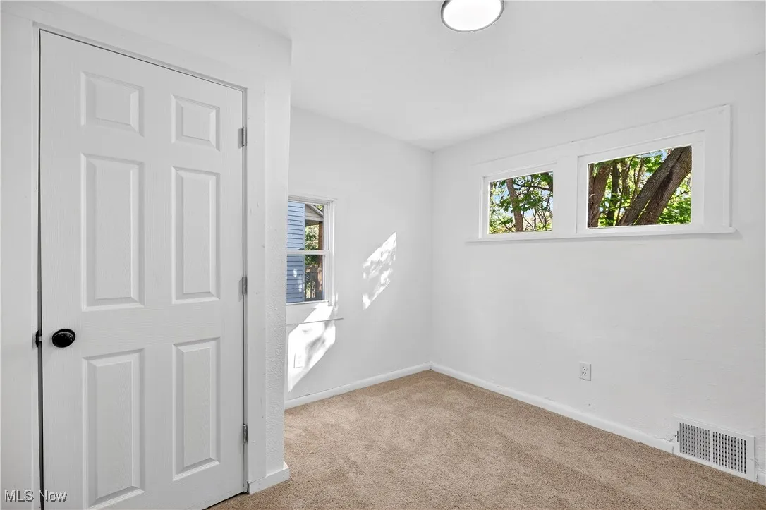 Spare room with light carpet and baseboards