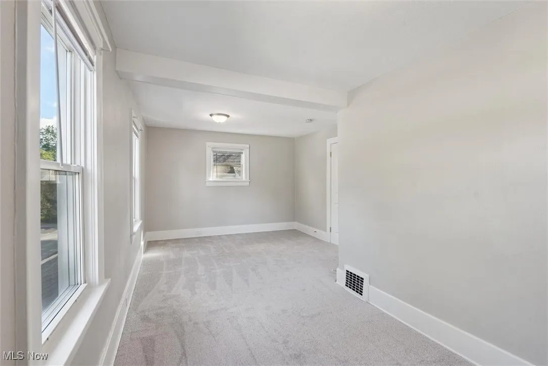 Empty room featuring light carpet and baseboards