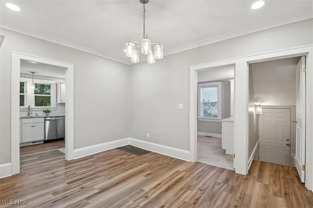 Unfurnished dining area with recessed lighting, light wood-style flooring, a chandelier, and crown molding
