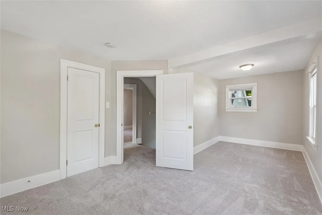 Unfurnished room featuring light colored carpet and baseboards