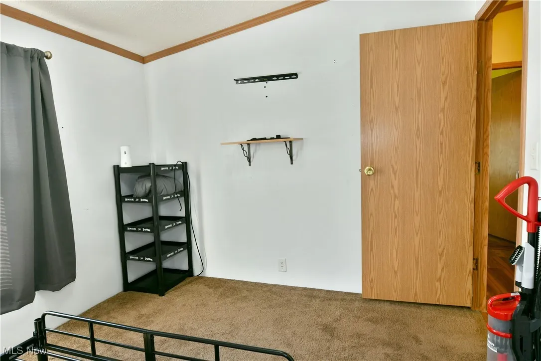 Carpeted bedroom featuring ornamental molding and a textured ceiling