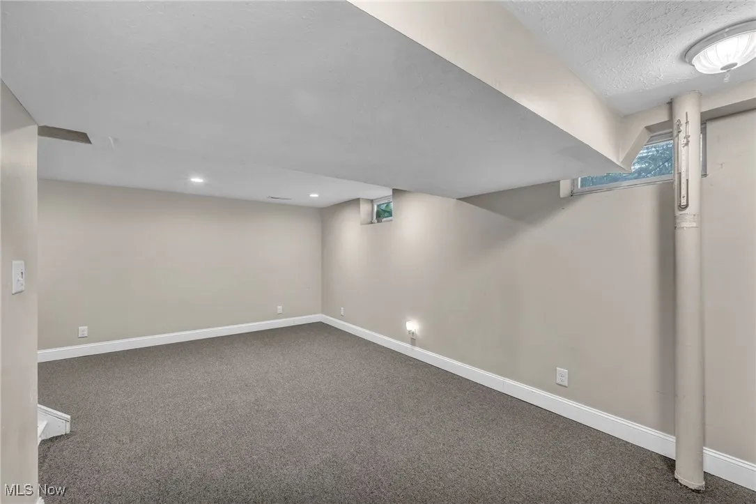 Basement featuring carpet flooring and a textured ceiling