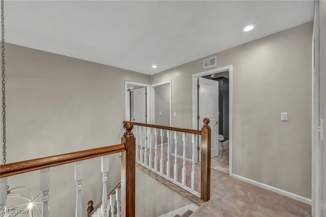 Hall featuring an upstairs landing, carpet flooring, and recessed lighting