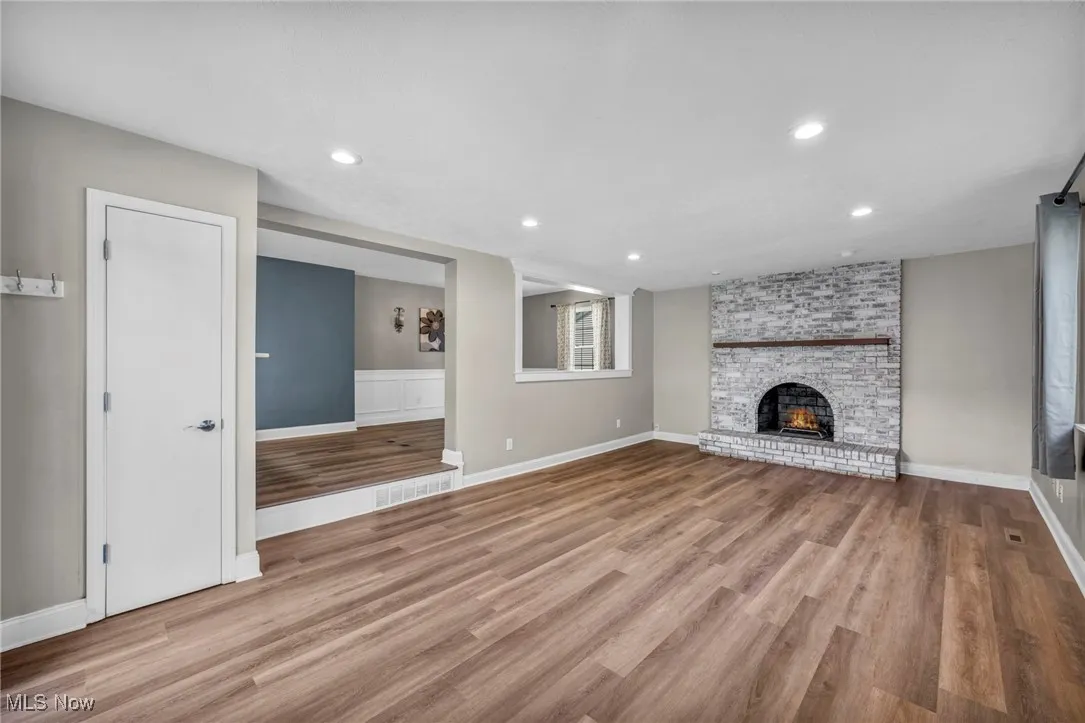 Unfurnished living room featuring light wood-style flooring, a fireplace, and recessed lighting
