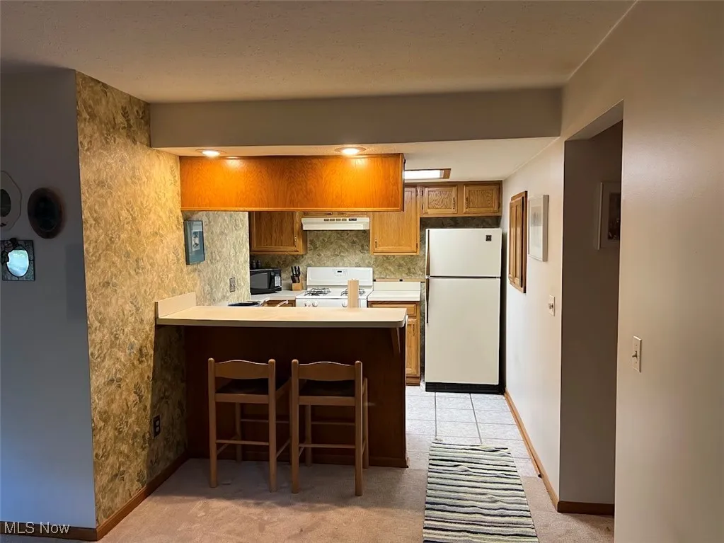 Kitchen with brown cabinets, and a breakfast bar,