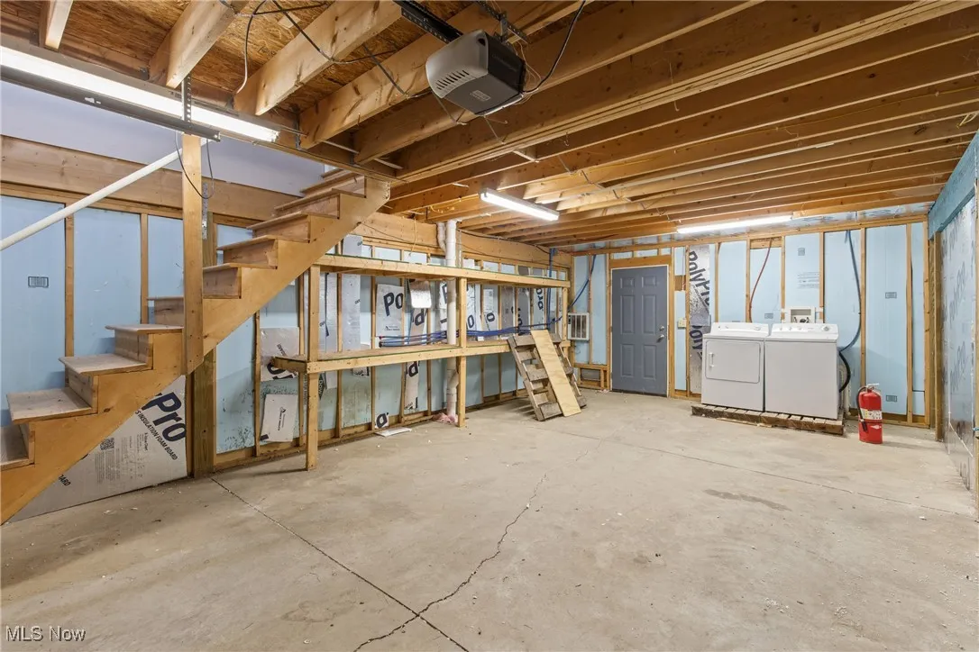 Below grade area featuring washing machine and clothes dryer and stairway