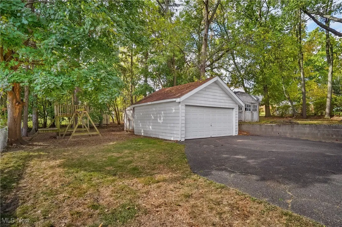 View of the detached 2-car garage, shed behind it and parat of the backyard.