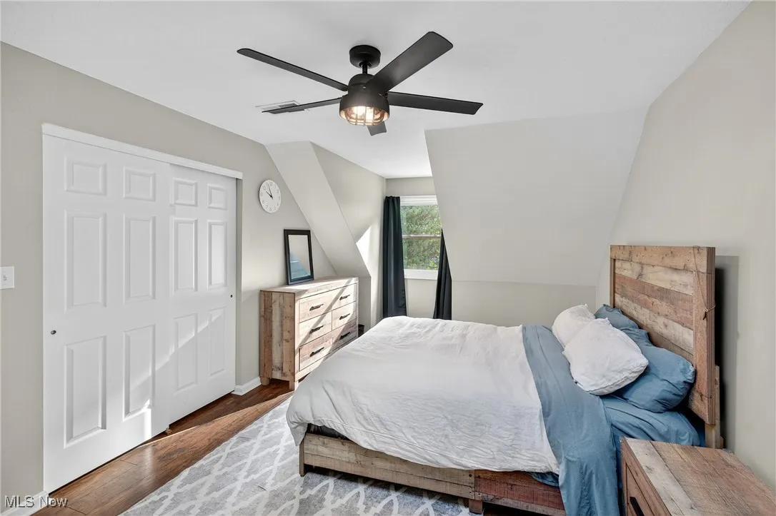 Bedroom featuring wood finished floors, a closet, and a ceiling fan
