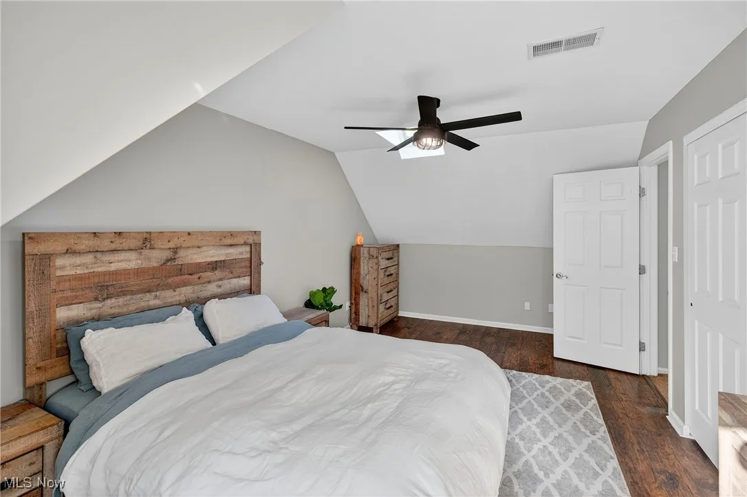 Bedroom featuring dark wood-style flooring, lofted ceiling, and ceiling fan