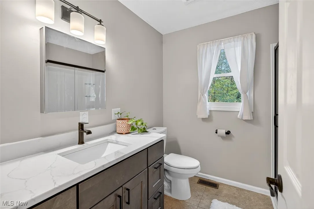 Full bath featuring vanity, a shower with curtain, and light tile patterned floors