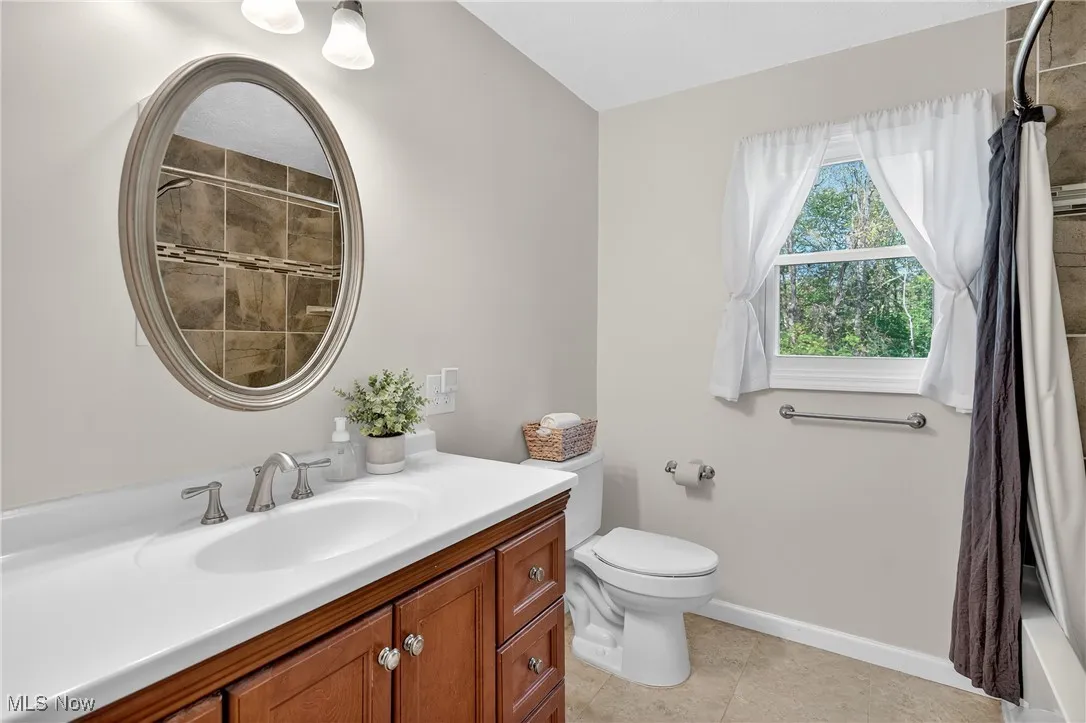 Full bath with vanity, tiled shower / bath combo, and light tile patterned floors