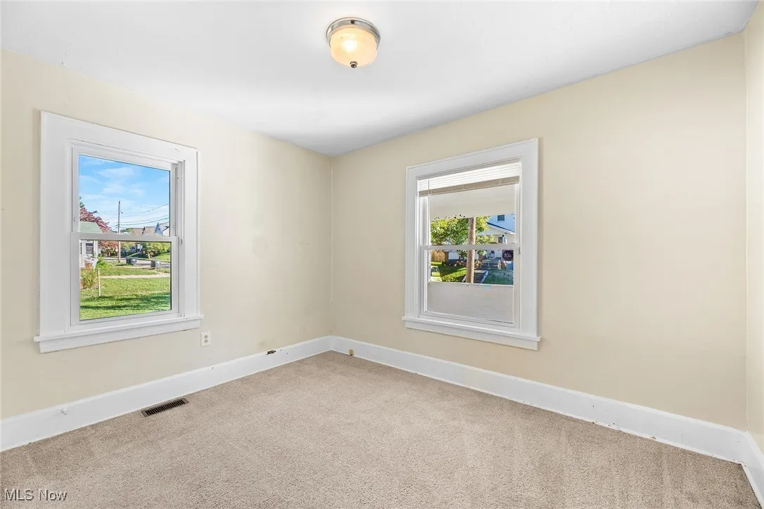 Spare room featuring baseboards and carpet floors