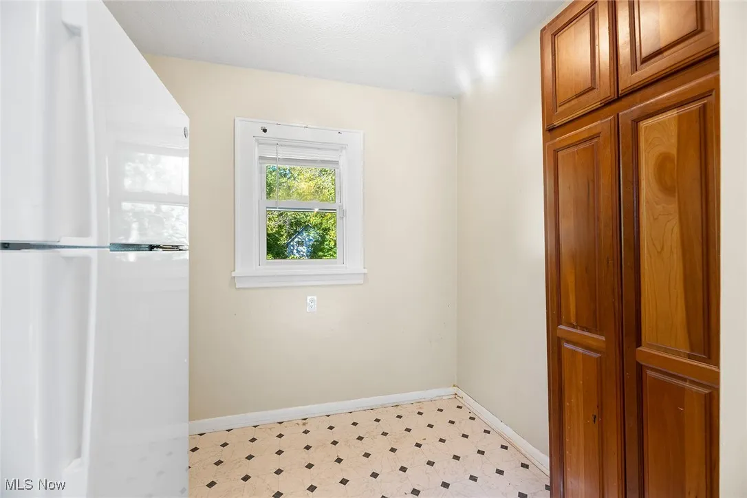 Laundry room with baseboards and light floors