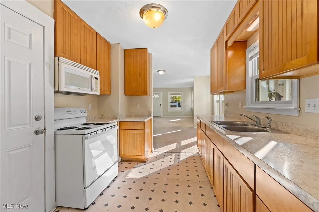 Kitchen with white appliances, light countertops, and light floors