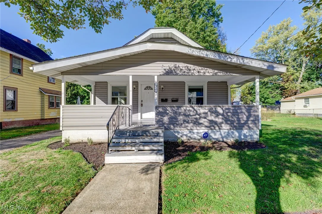 View of front of property with a porch and a front lawn
