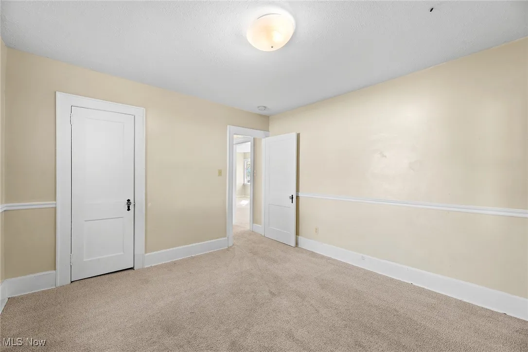 Unfurnished bedroom with carpet flooring and baseboards