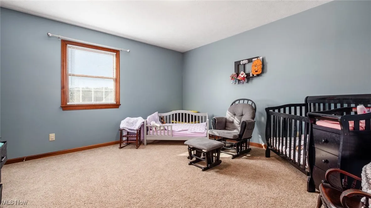 Bedroom featuring a crib and carpet
