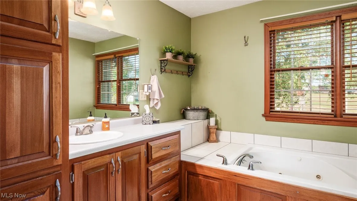 Bathroom with a tub with jets and vanity