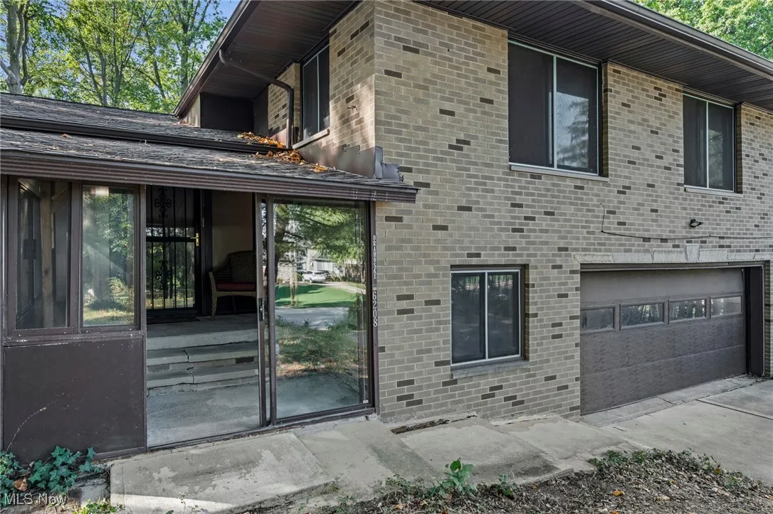 View of side of home featuring brick siding and a garage