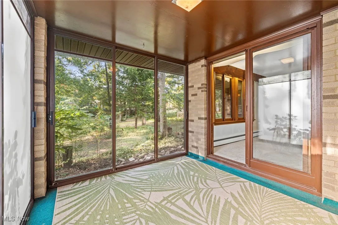 Unfurnished sunroom with a baseboard heating unit