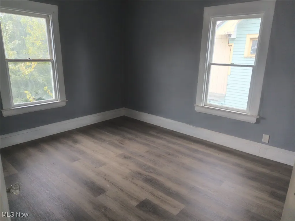 Spare room featuring wood finished floors and baseboards