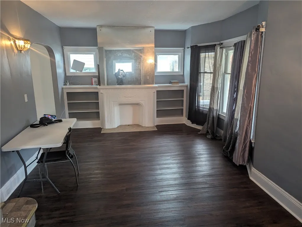 Living room featuring dark wood-type flooring and arched walkways