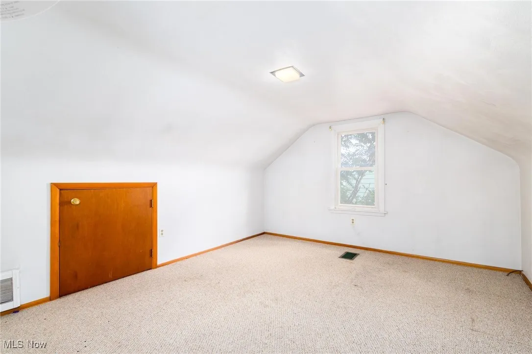 Additional living space featuring lofted ceiling and carpet floors