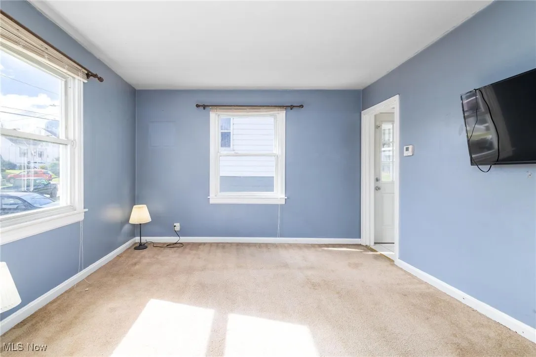 Empty room with carpet flooring and baseboards