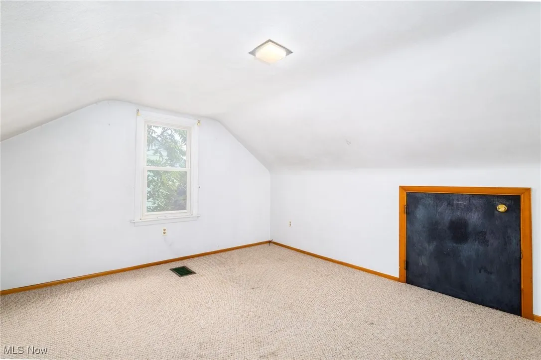 Bonus room featuring vaulted ceiling and carpet flooring