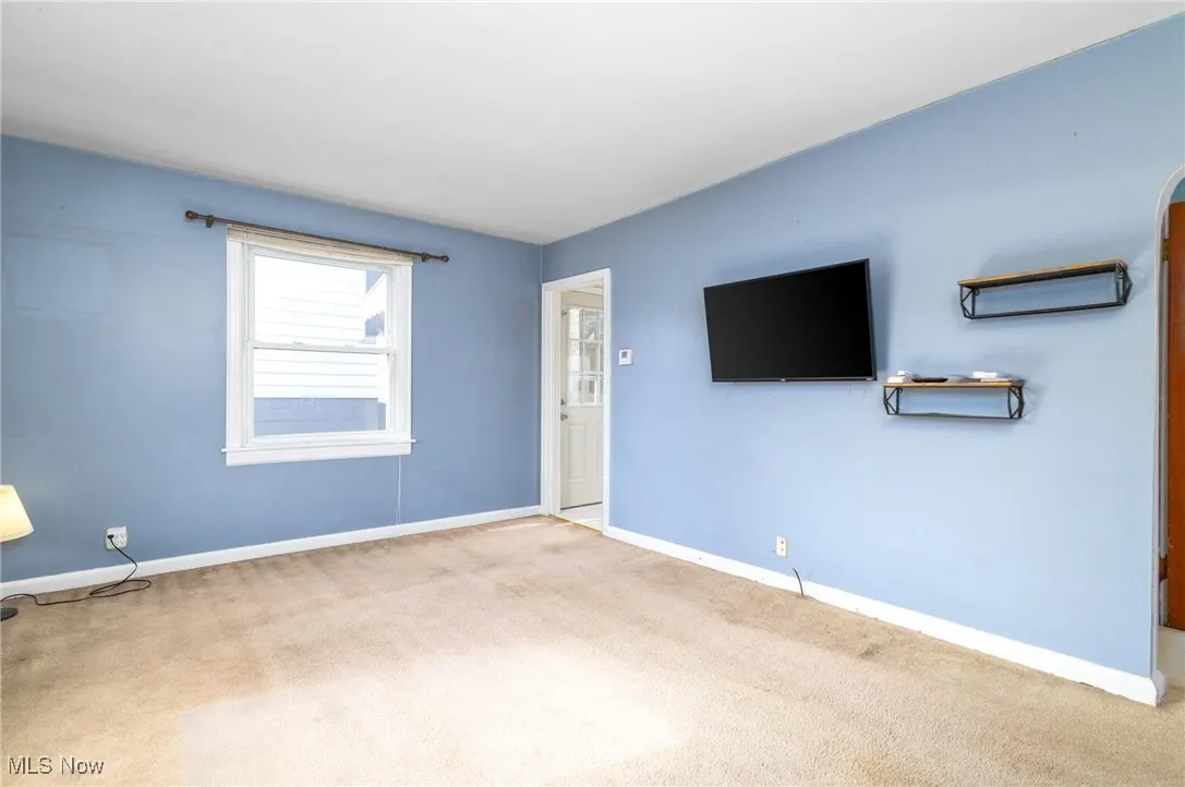 Unfurnished living room with carpet flooring and baseboards