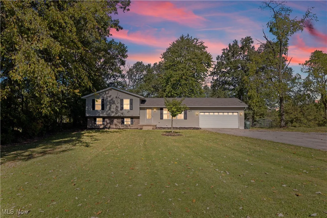 Split level home featuring a yard, driveway, and an attached garage