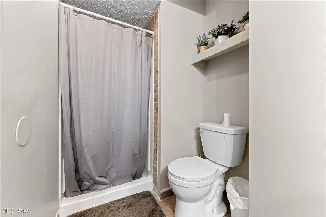 Full bathroom with a stall shower and tile patterned flooring