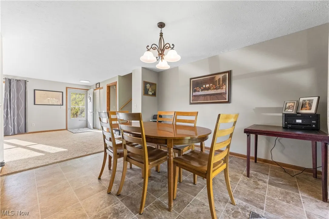 Dining space featuring a chandelier and a textured ceiling