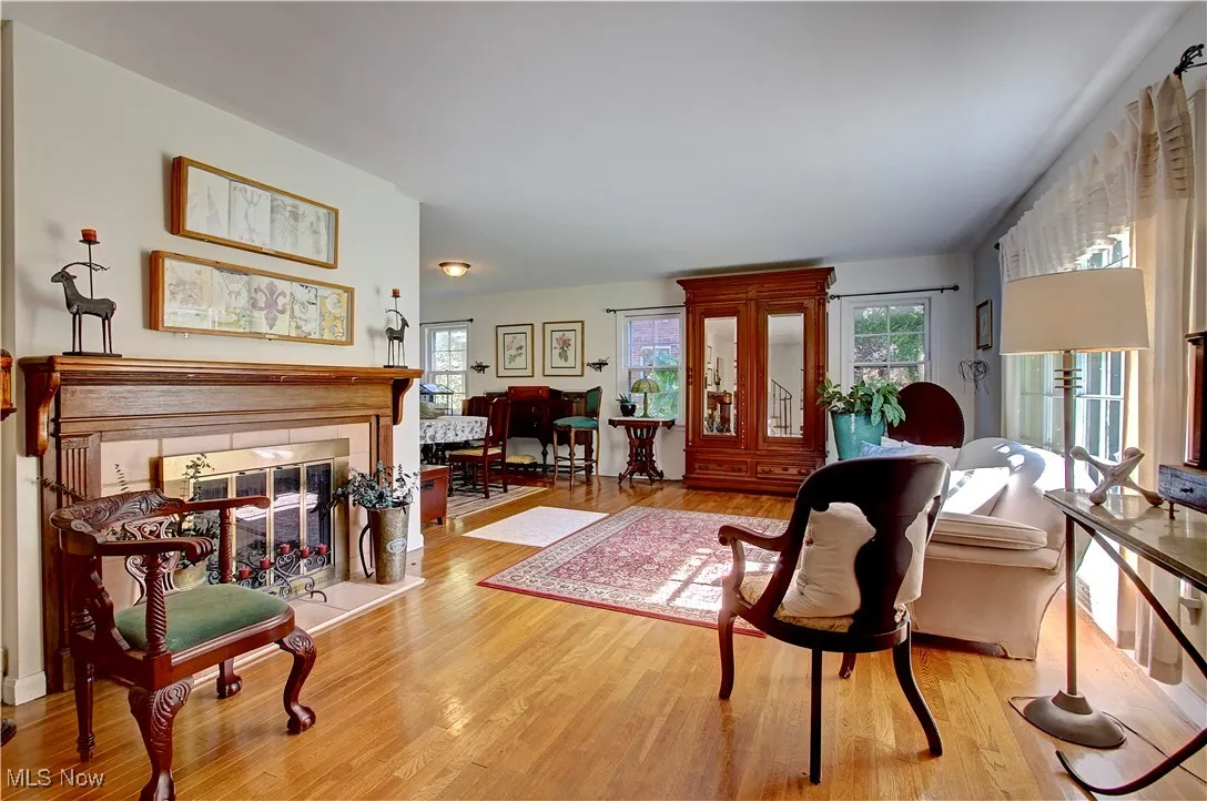 Living area featuring light wood finished floors, healthy amount of natural light, and a tile fireplace