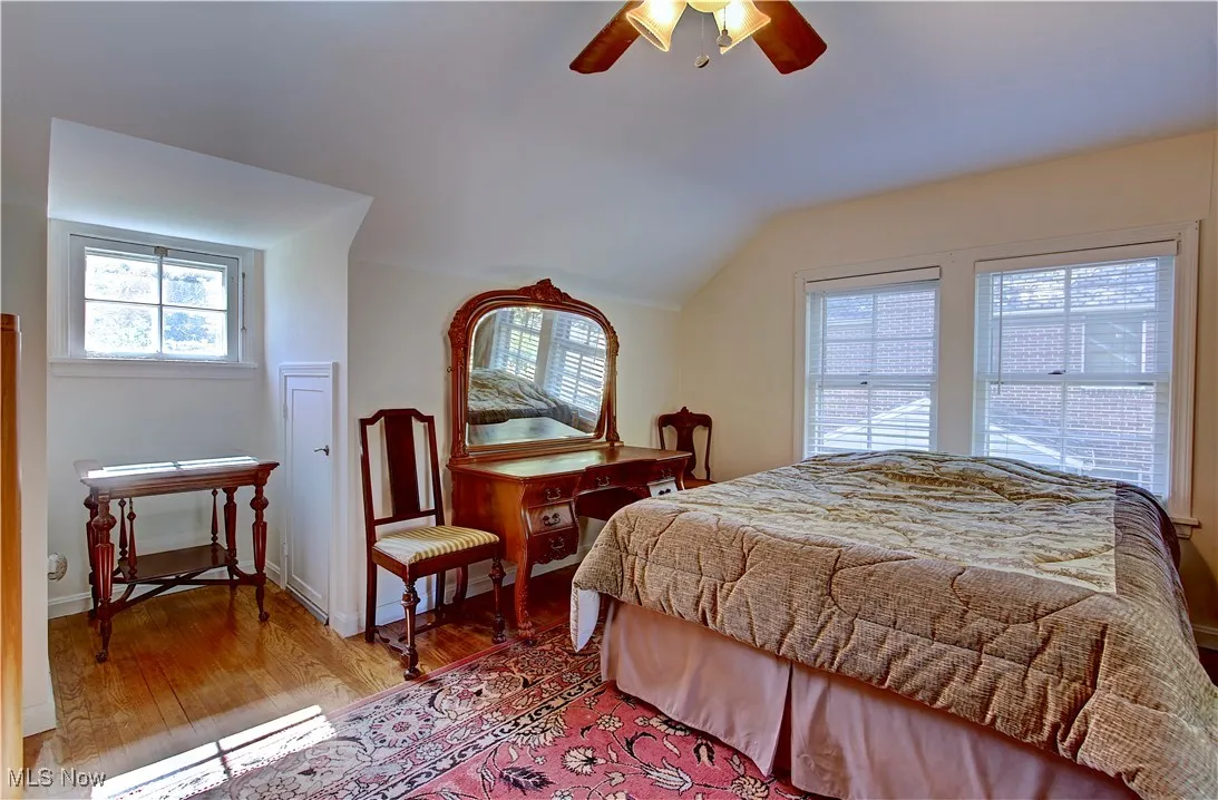 Bedroom with wood finished floors, vaulted ceiling, and ceiling fan