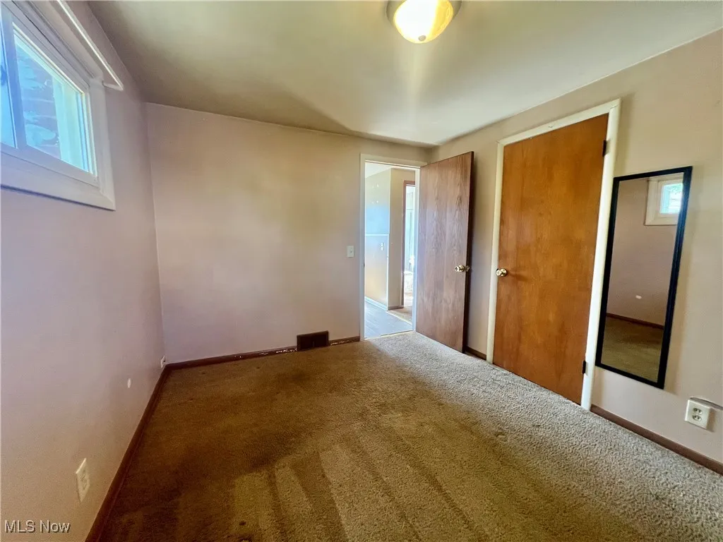 Carpeted empty room featuring baseboards