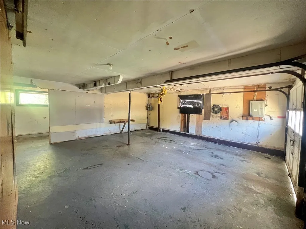 Below grade area featuring plenty of natural light, a garage, and electric panel