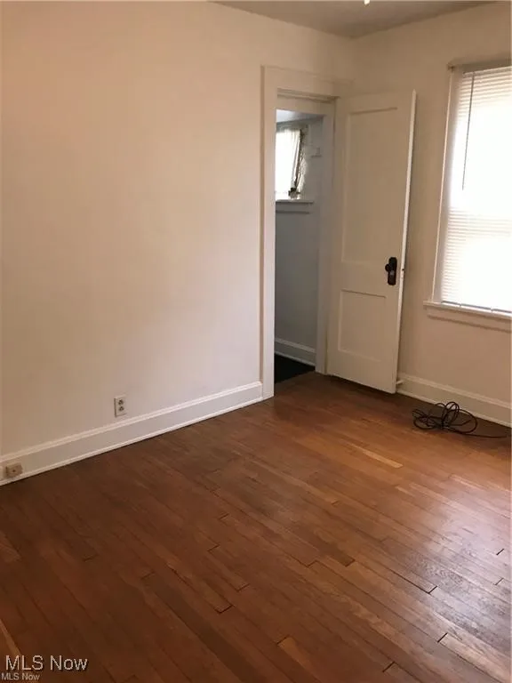 Unfurnished room featuring dark wood-type flooring