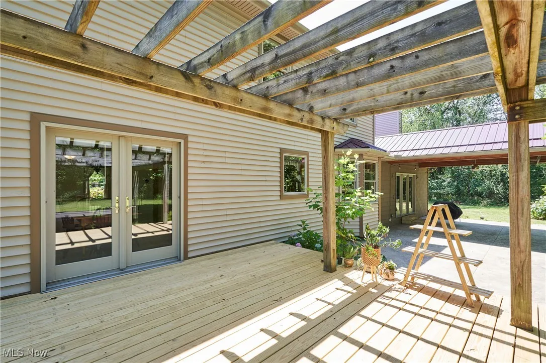 Deck with a pergola, french doors, and a patio area