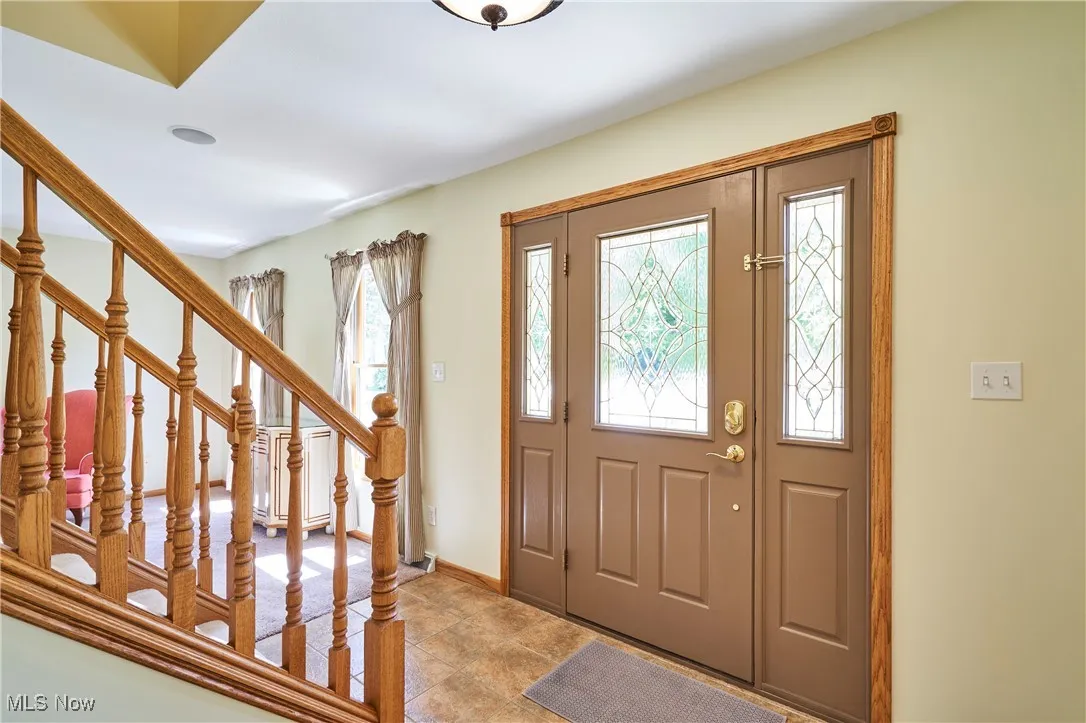 Foyer entrance featuring baseboards and stairway