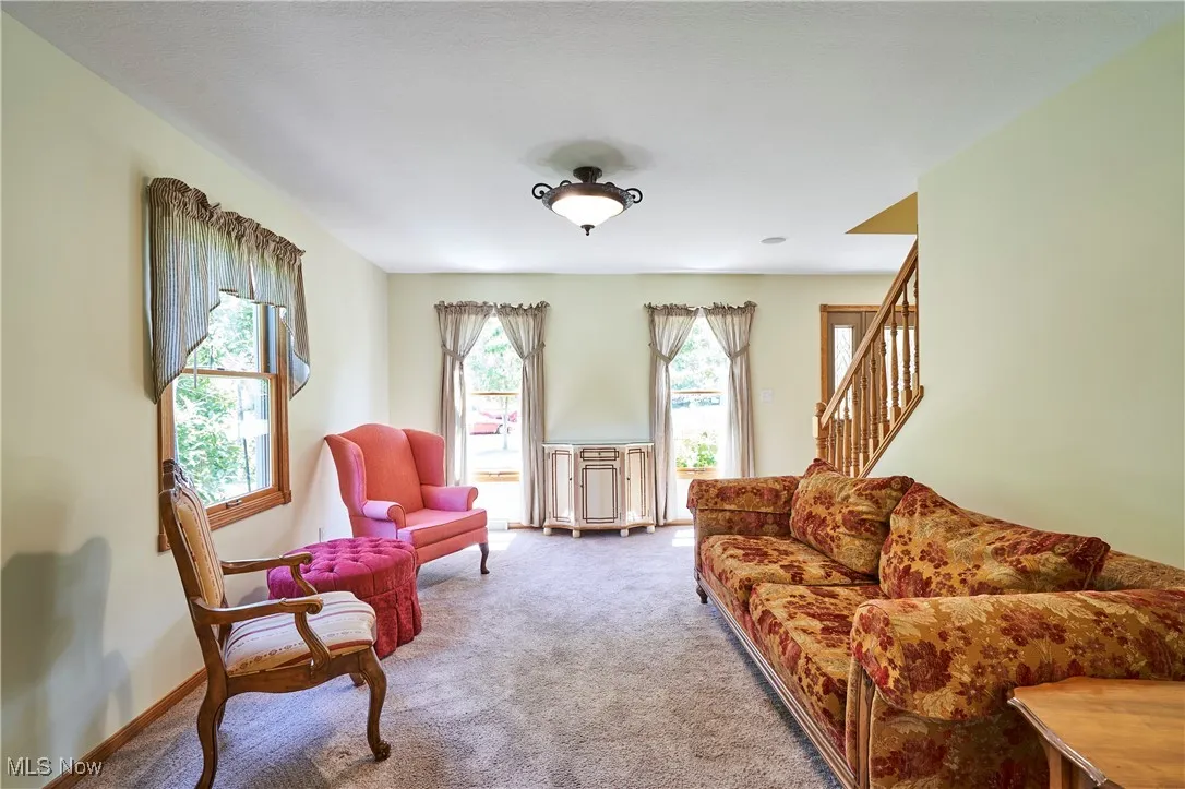 Sitting room featuring carpet and stairway
