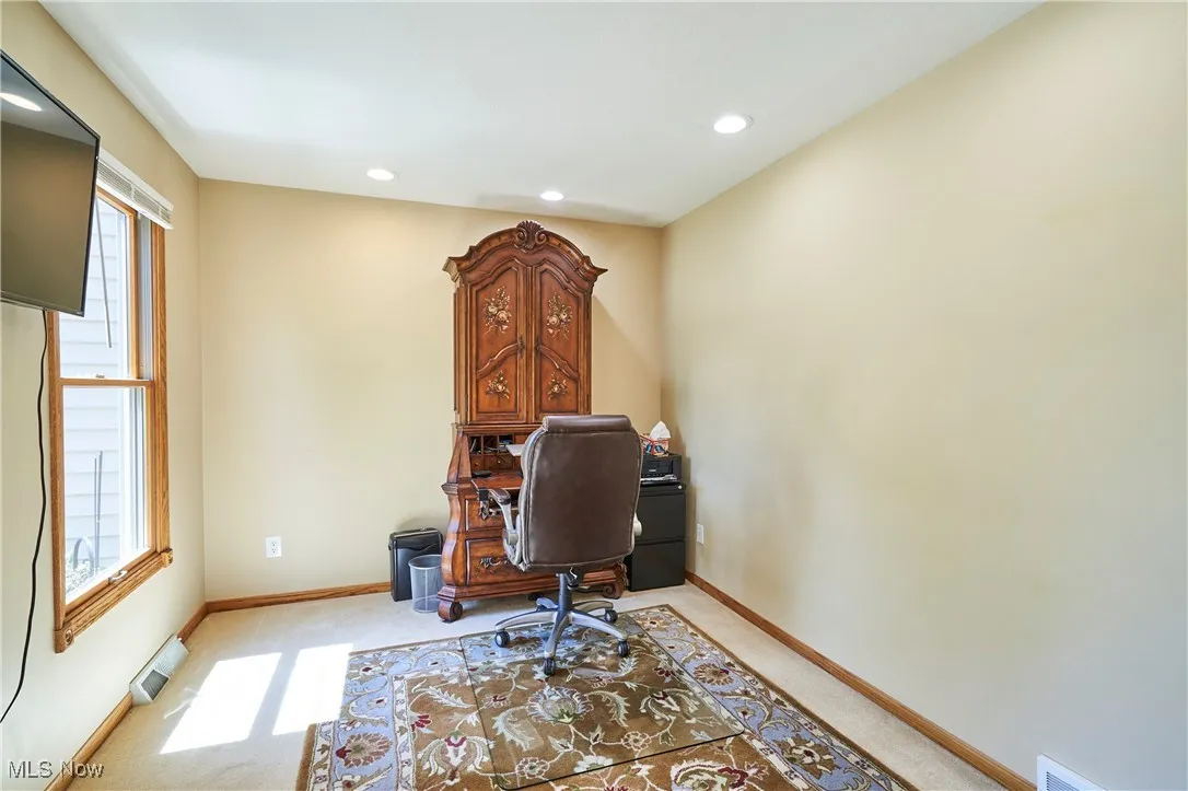Home office with recessed lighting and light colored carpet
