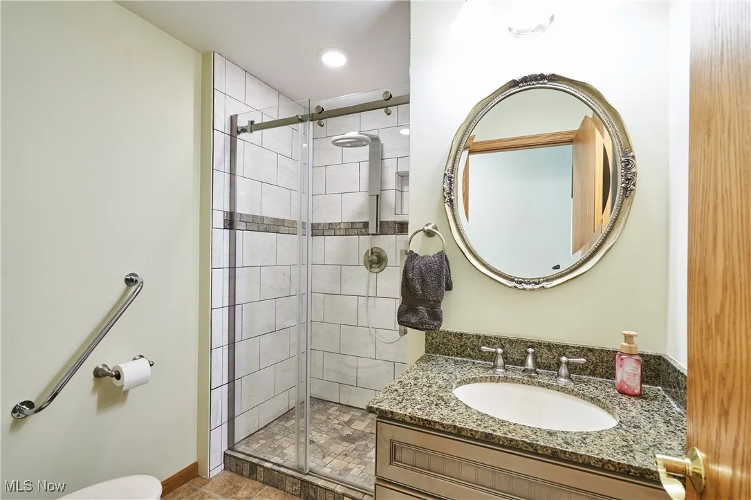 Bathroom featuring a shower stall and vanity