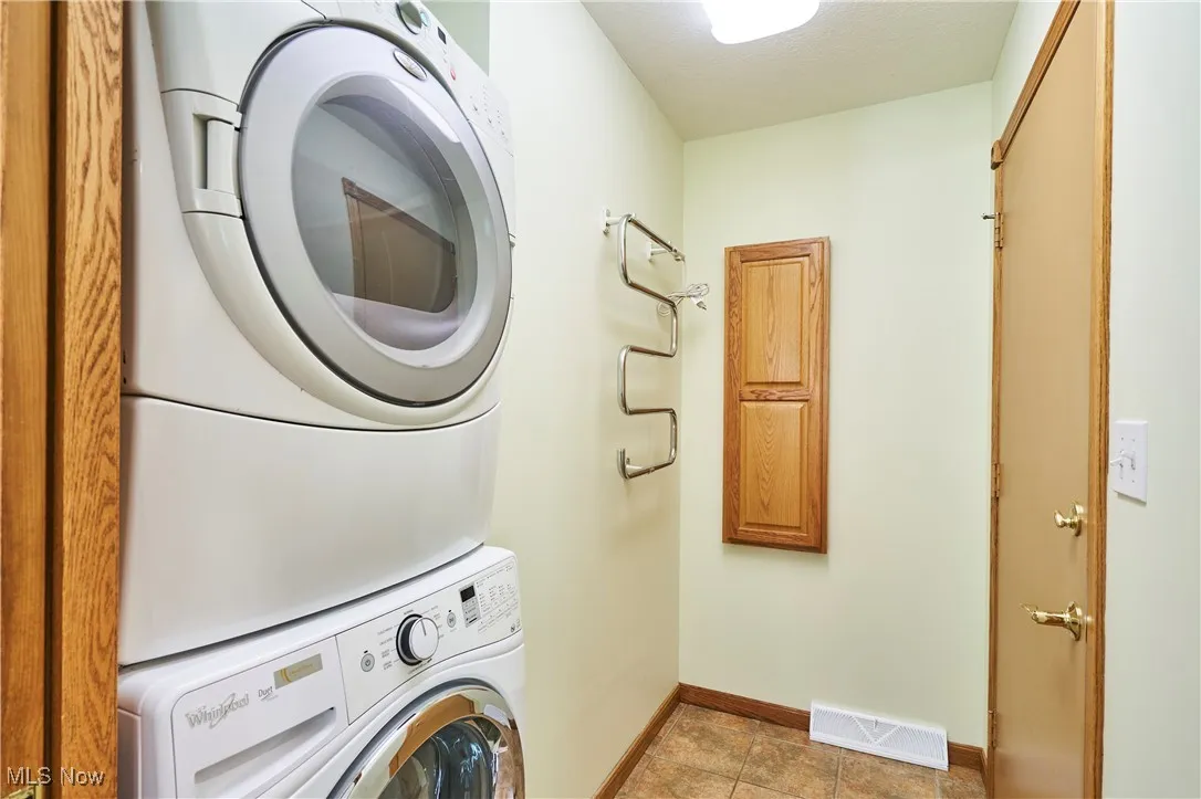 Washroom featuring estacked washer and dryer and baseboards
