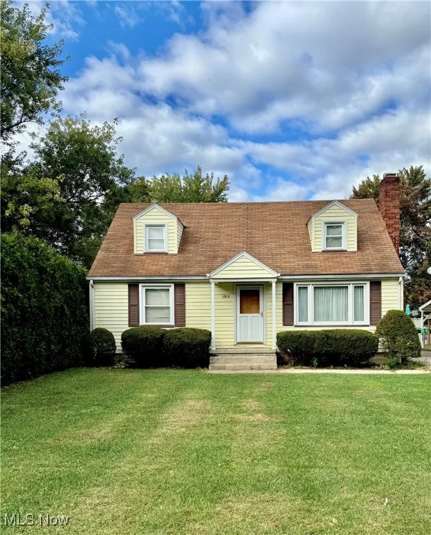 New england style home with a front lawn and a chimney