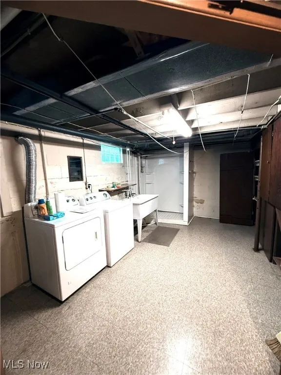 Basement with light flooring and separate washer and dryer